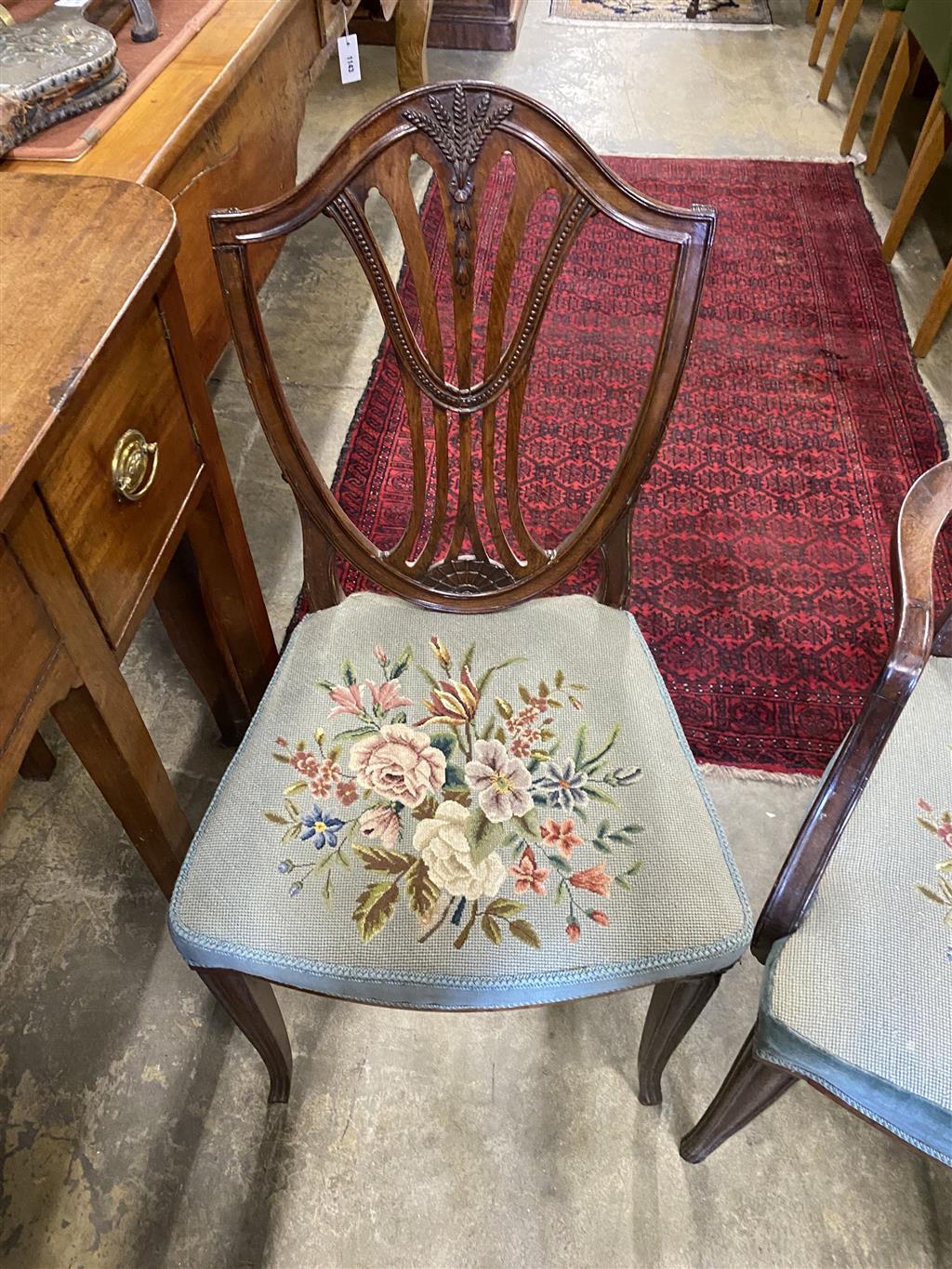A set of six Hepplewhite style mahogany shield back dining chairs with tapestry drop in seats (two with arms)